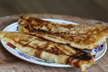 fresh baked pancake with cheese and bacon on plate on wooden background