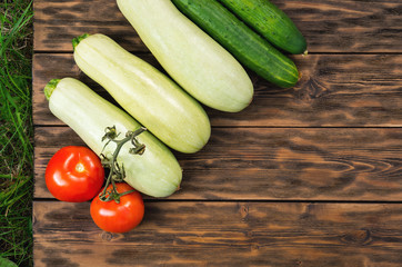 Tomatoes, cucumbers and squash on wooden boards