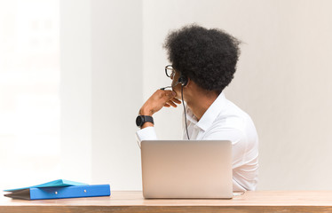 Young telemarketer black man from behind, looking back