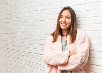 Young woman wearing pajama smiling confident and crossing arms, looking up