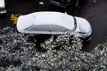 Parking sign for disabled under car covered first snow, view from the window of house