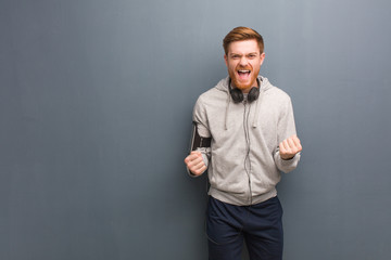 Young fitness redhead man surprised and shocked