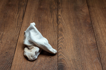 A young man holds his smelly socks and covers his nose with his hand. Nasty smell. Stink legs, fungus on the legs