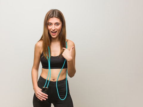 Young fitness russian woman surprised, feels successful and prosperous. Holding a jump rope.