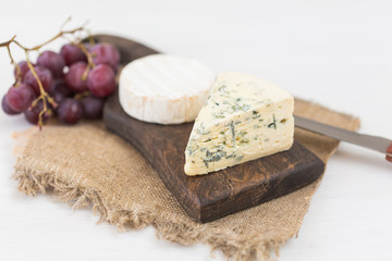 Fototapeta na wymiar Blue cheese or brie with grapes and nuts