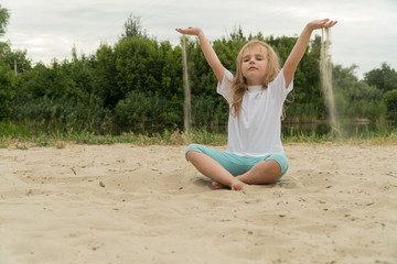 Girl practicing yoga on the beach. Toned image.