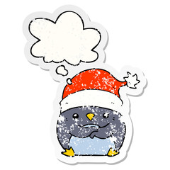 cute cartoon penguin wearing christmas hat and thought bubble as a distressed worn sticker