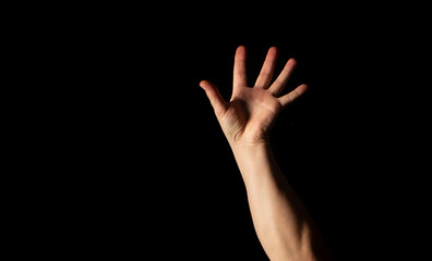 The hand of a young man on a black background