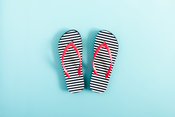 Blue flip flops on blue background. Flat lay, top view, copy space