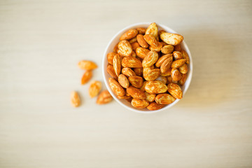 White ceramic bowl with almond on the table.