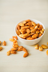 White ceramic bowl with almond on the table.