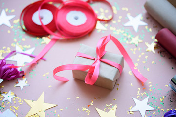 A gift with a pink flight on a festive background with stars.