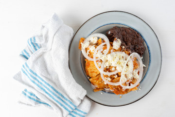 Mexican red chilaquiles with beans and cheese
