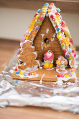 homemade gingerbread house with witch and Hansel and Gretel in front of it