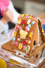 Gingerbread house decorated with sugar icing, gummy bears and other sweets