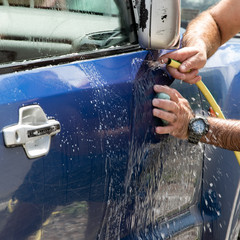 Close up view of man hands washing automobile. .