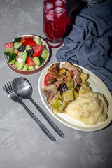 Mashed potatoes with meat stew. Courgettes, tomatoes, blue. Greek salad with olive oil. 