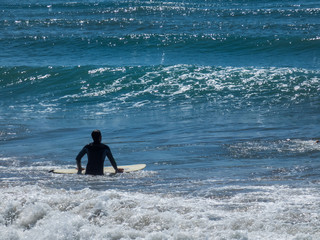 Surfer waiting big wave in Costa Calida , Mursia, Spain. Sunny day, shining water.