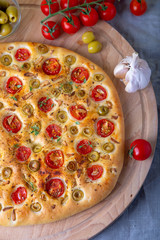 Focaccia with tomatoes and olives. Traditional Italian bread. Homemade baking. Close-up, selective focus.