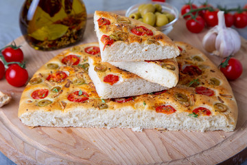 Focaccia with tomatoes and olives. Traditional Italian bread. Homemade baking. Close-up, selective focus.