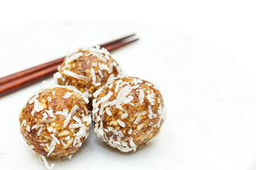 Close up healthy date and nut balls with coconut.