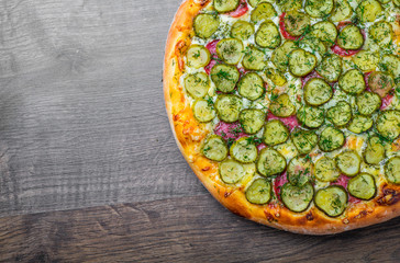Pizza with Mozzarella cheese, salami, bacon, Tomato sauce, fresh dill, Spices and pickled cucumbers. big dill pizza on wooden table background