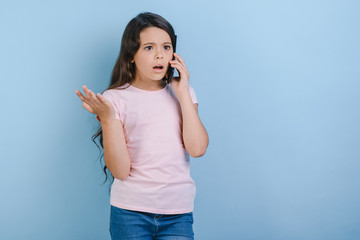 Girl talking on mobile phone with surprised and gesturing arns. - Image