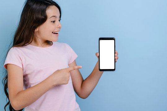 Wonder girl holding a smartphone and pointing to screen looking in it- Mockup image of white empty blank screen of phone