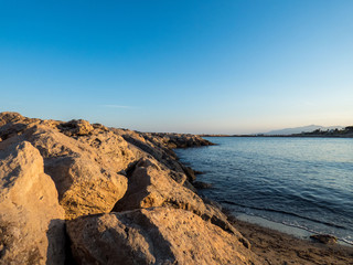 Fototapeta na wymiar Sea sunset view with stones. Calm sea.