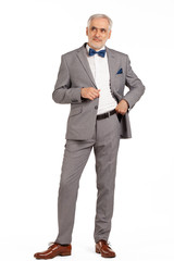 Portrait of smart and handsome intelligent senior man in stylish grey suit isolated on white background