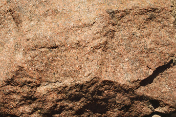 Aged rough brown granite stone texture with cavities