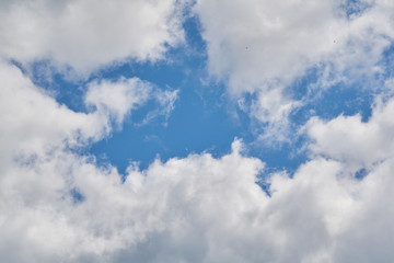 A piece of blue sky among beautiful, white-grey clouds