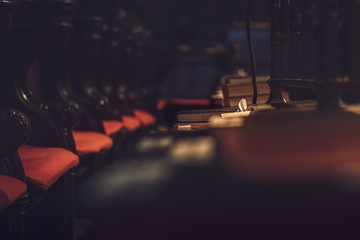 A dark and moody shot of a single bible in focus in a large Cathedral