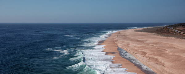 Landscape of surfing beach in Nazare, Portugal. The place of biggest Atlantic ocean waves in the world.