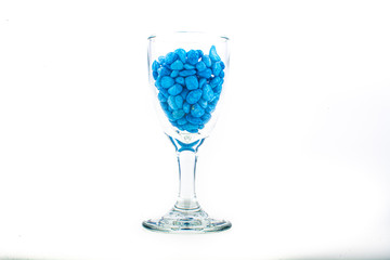 Blue pebbles stone inside glass with empty copyspace area for slogan or advertising text message, over isolated white background.