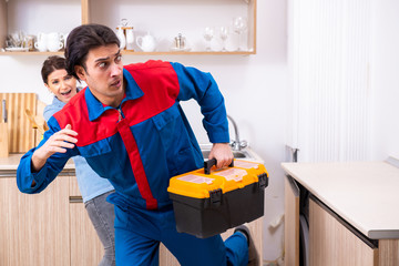 Young male repairman repairing tap 