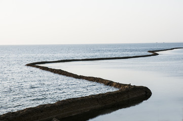Ancient stone constructions on the beach of Chipiona Spain to catch fish at low tide