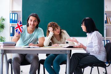 Old female english teacher and students in the classroom 