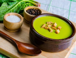 Spinach soup served on wooden board