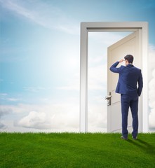 Businessman standing in front of door into future