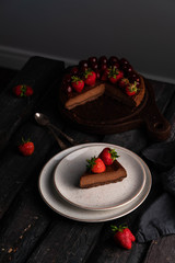 chocolate cheesecake strawberries on top dark backdrop, dark background, a dessert