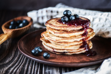 Pancakes with blueberry and honey. On a wooden table with a white towel