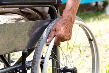 A disabled man is sitting in a wheelchair ,Holds his hands on the wheel. Handicap people Concept.