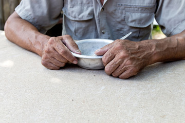 Hungry. Poor old man's hands an empty bowl. Selective focus. Poverty in retirement. Alms