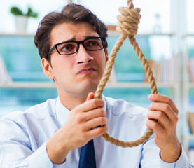 Unhappy businessman thinking of hanging himself in the office