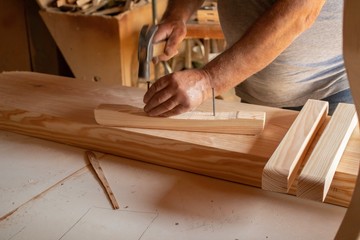 carpenter cutting plank with saw