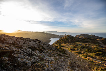 Sunset over sea cliffs and low clouds with clear sky