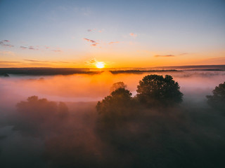 Fototapeta na wymiar Sunrise over spring meadow. Spring aerial landscape. Spring sunrise over green forest and field with river and fog.