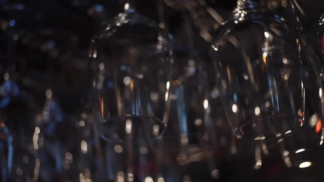 Close-up view of clean washed and polished glasses for wine and other alcoholic drinks hanging over the bar counter. Frame. Decoration,Interior,design concept