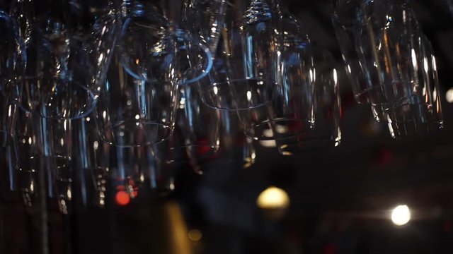 Close-up view of clean washed and polished glasses for wine and other alcoholic drinks hanging over the bar counter. Frame. Decoration,Interior,design concept